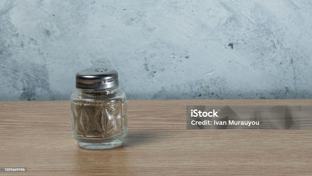 Close-Up view of pepper shaker On Table on light gray wall background. Close-Up view of pepper shaker On Table on light gray wall background. Space for text. Cooking concepts. Aromatherapy Stock Photo