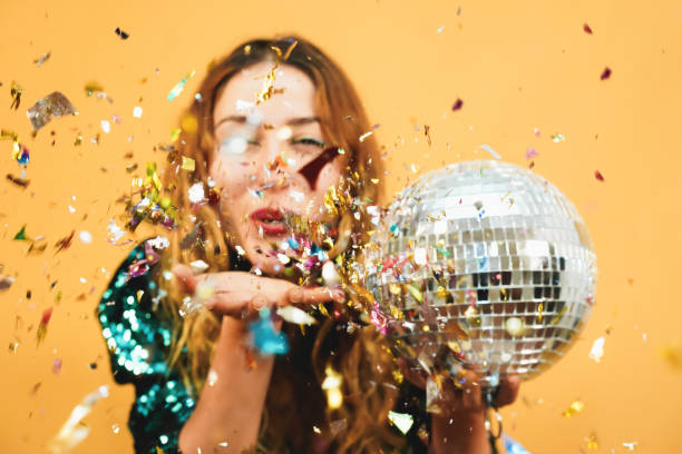 Blurred happy girl blowing confetti holding vintage disco ball - Defocused photo Blurred happy girl blowing confetti holding vintage disco ball - Defocused photo Dance Party for One stock pictures, royalty-free photos & images