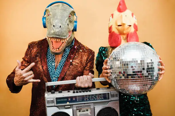 Photo of Crazy couple listening music with vintage boombox stereo at party - Focus on man face mask