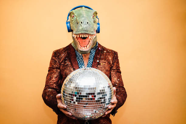 istock Crazy happy man dancing disco music wearing t-rex mask - Focus on face 1359669800
