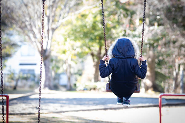 ブランコ上の子供の背面図 - さびしい ストックフォトと画像