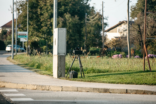 Mobile police radar built up on a meadow next to a street for traffic speed control,horizontal