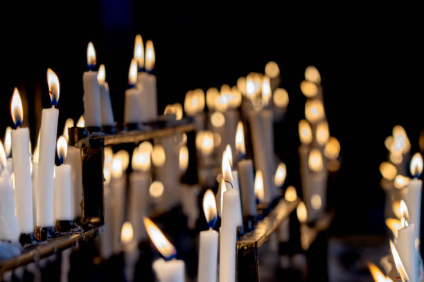 istock Religion background with burning white candles on fireplace at Church 1359676840