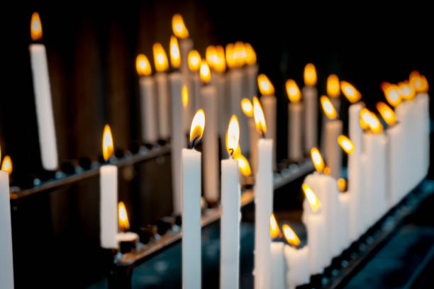 istock Religion background with burning white candles on fireplace at Church 1359676853