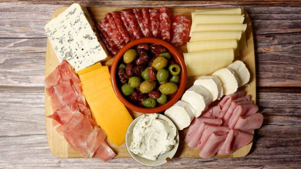 istock Cheese sausage platter with olives on a rustic wooden background 1359677595
