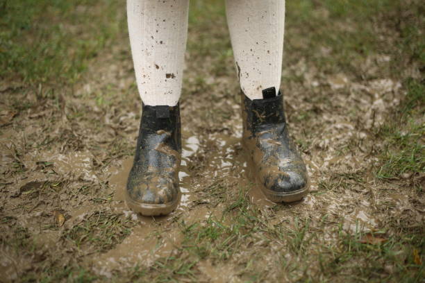 istock Childs boots in dirt rainy day on grass black boots 1359678946
