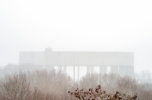 New architectural water tower in the city. The height is 39 meters (128 feet). Deep morning fog. Selective focus.