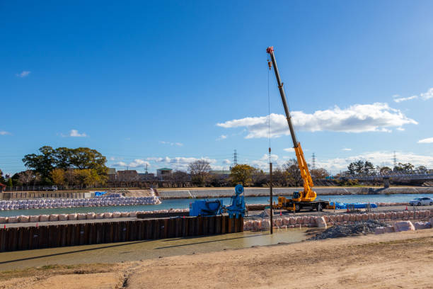 istock Mobile crane lifting a long steel material at construction site 1359685995