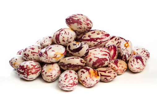 Pile of freshly harvested borlotti beans against a white background