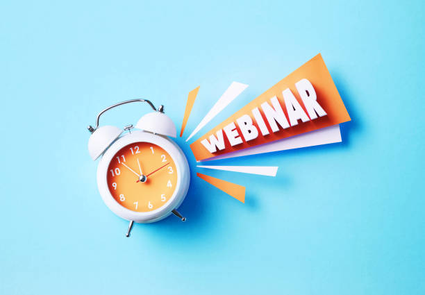 istock Webinar Word Sitting Next To A White Alarm Clock On Blue Background 1359688214