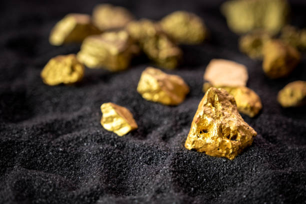 Pure gold from the mine that was unearthed was placed on the black sand. Pure gold from the mine that was unearthed was placed on the black sand. gold mine photos stock pictures, royalty-free photos & images