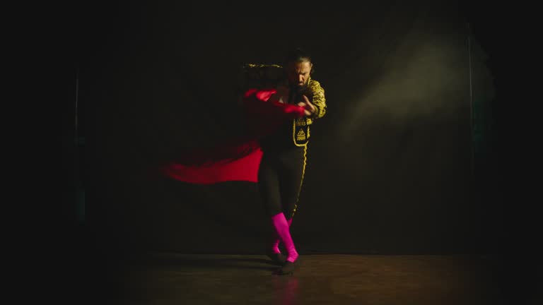 Male dancer or toreador imitating moves of matador bullfighter on black smoky background .  Man bullfighter dressed in bullfighting costume . Shot on ARRI Alexa cinema camera in Slow Motion