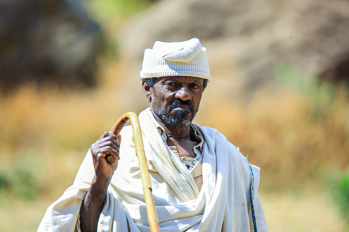 Lalibela, Ethiopia - August 20, 2020: Old Ethiopian Priest in Traditional Clothes going to the Church for pray