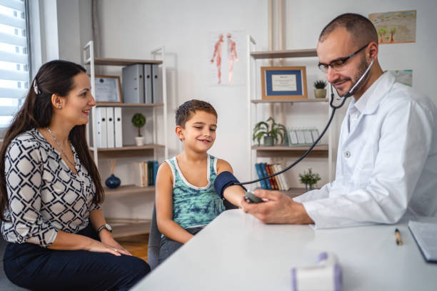 male doctor checking little boys blood pressure - child little boys male caucasian imagens e fotografias de stock