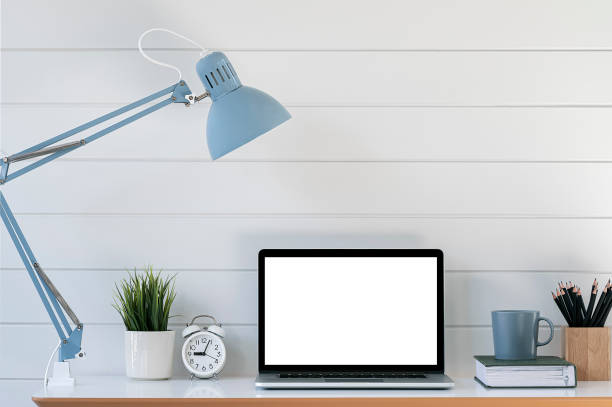 istock blank screen laptop computer and supplies on wooden table. 1359694820