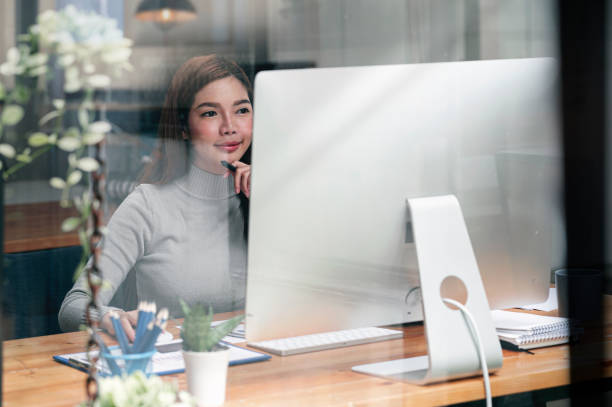 istock Asian woman working on desktop computer at home. 1359694829