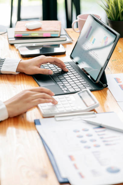 istock woman hand working on portable table and graph chart. 1359695240