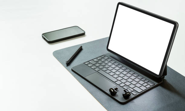 istock blank screen portable tablet with magic keyboard and gadget on white table. 1359695259