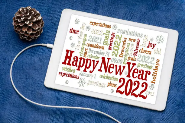 Happy New Year 2020 greetings card  - word cloud on a digital tablet with a decorative frosty pine cone