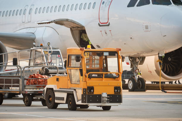 ciężarówka bagażowa i samolot odrzutowy na lotnisku - luggage cart airport luggage cargo container zdjęcia i obrazy z banku zdjęć