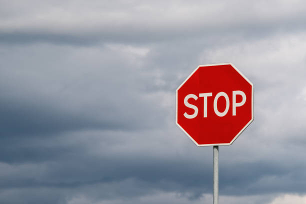 istock Stop sign against dramatic cloudy sky. Abstract background and texture for design. 1359699223