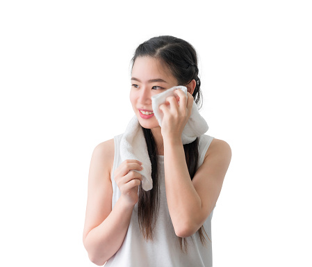 Portrait of happy beautiful asian woman using white towel wiping sweat from her face after exercise isolated on white background. Beauty girl smiling and wipe her face with towel after washing face.