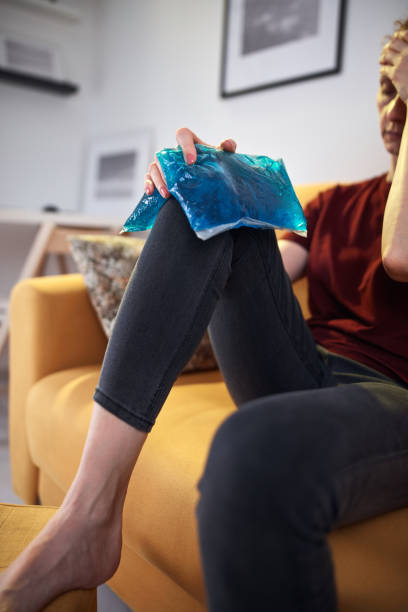 femme souffrant de douleur au genou à la maison à l’aide d’un sac de gel glacé. - ice women ice pack physical injury photos et images de collection