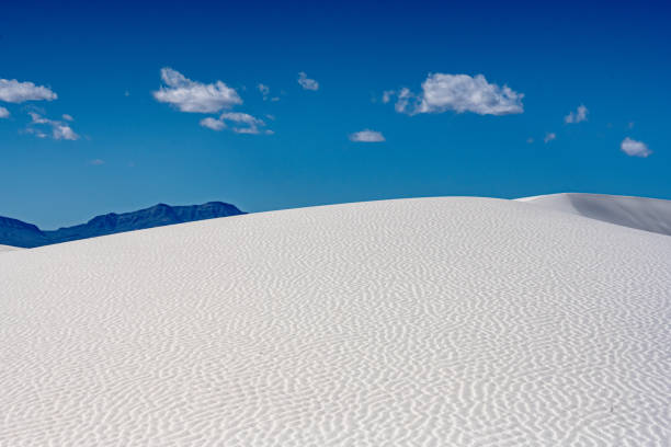istock Puffy Clouds Float Over Undisturbed Ripples of White Sand 1359706654