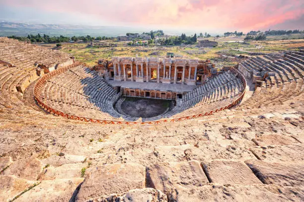Photo of Amphitheater in ancient city of Hierapolis under dramatic pink sky