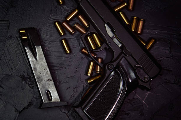 istock Pistol with cartridges on black concrete table. 1359711840