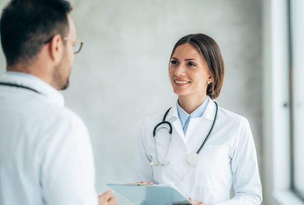 istock Two healthcare workers talking at hospital 1359711886