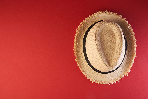 Top view of Straw beach hat  for men isolated on red background