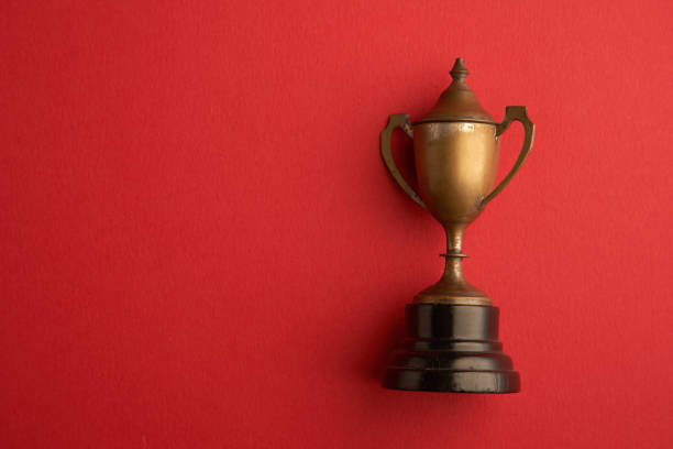 istock old bronze trophy on red background 1359713034