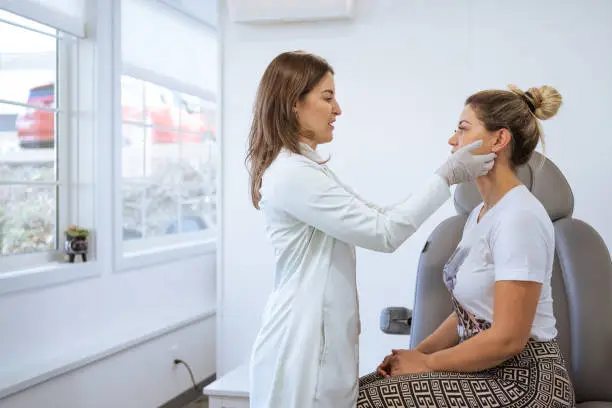 Female dermatologist performing a procedure on a client