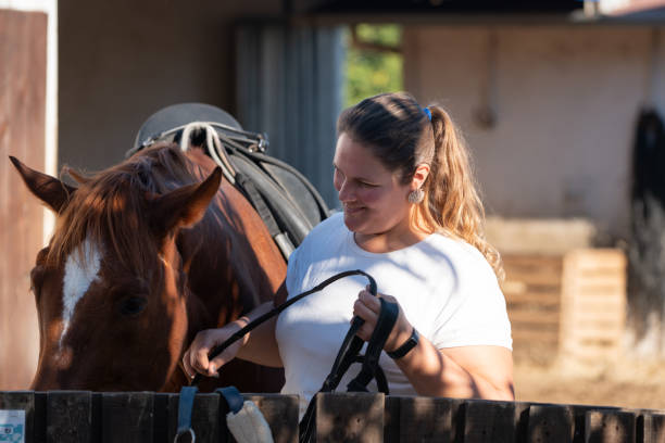 istock Happy rider saddles a horse. 1359714360