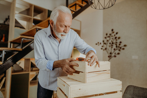 Senior man fixing furniture at his home