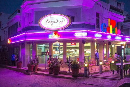Dakar, Senegal - May 31, 2014: Candy store and bakery with night lighting on the maritime avenue of the city center