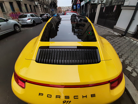 Bucharest, Romania - November 23, 2021: An yellow Porsche 911 Carrera is parked on a street in Bucharest.