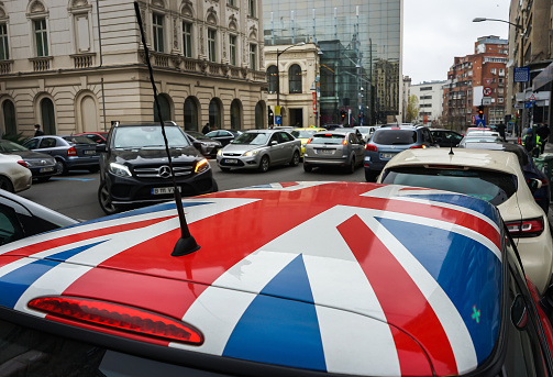Bucharest, Romania - Decembrie 16, 2021: A Mini Cooper car with a British flag painted on the roof is parked on a street in the center of Bucharest.