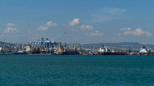 View of Novorossiysk Commercial Sea Port for loading container ships Diadema Nassau Supereco and Horizon. Turquoise water in foreground. View of Novorossiysk Commercial Sea Port for loading container ships Diadema Nassau Supereco and Horizon. Turquoise water in foreground. Novorossiysk, Russia - September 15, 2021 krasnodar krai stock pictures, royalty-free photos & images