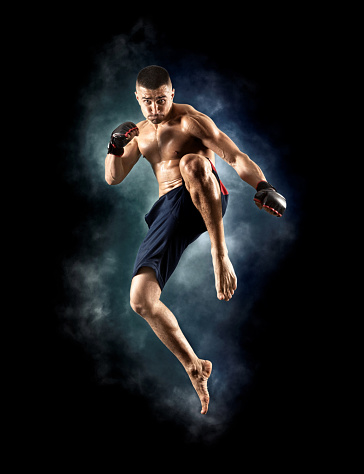 MMA male fighter jumping with a knee kick
