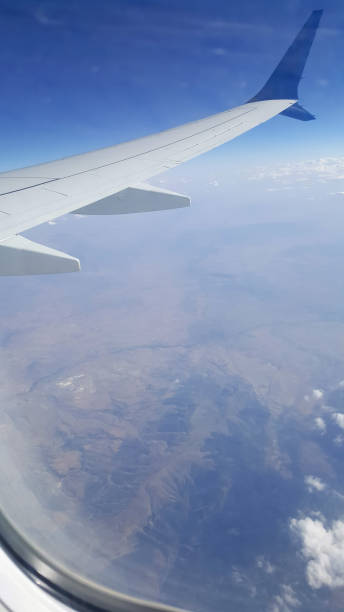 istock Looking through window aircraft during flight in wing with a nice blue sky 1359720855