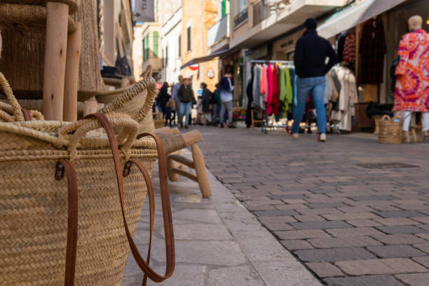 Close-up of a wicker basket of Majorcan handicraft called Senalla. In the background, out of focus, the weekly street market of the Majorcan town of Santanyi