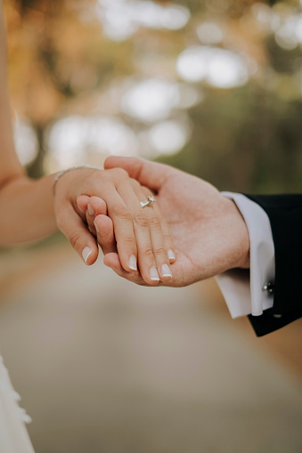 Man holding his girlfriend's hand and woman showing her ring