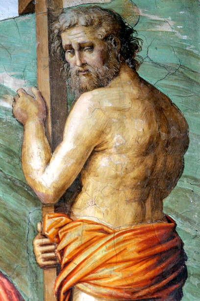 Dramatic view of a wooden crucifix of Jesus Christ inside an ornate Cathedral, surrounded by gold details and painted dome ceiling. Duomo di Santa Maria Annunziata. Salo, Italy.