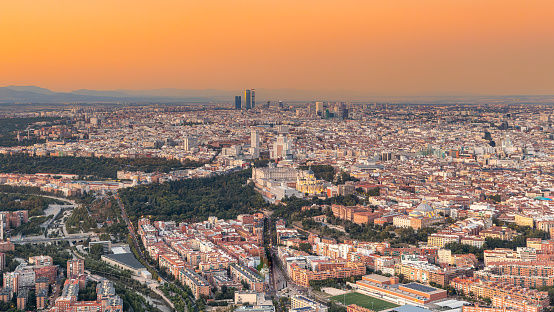 Vistas aéreas de la ciudad de Madrid durante la puesta de sol en un día despejado, pudiendo observar las cinco torres, el centro financiero, la catedral de la Almudena, el Palacio Real y Madrid Río photo