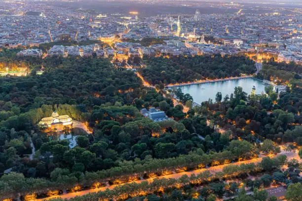 Photo of Aerial views of the city of Madrid during sunset on a clear day, being able to observe the Retiro Park, the Almudena cathedral, the Royal Palace and the Crystal Palace