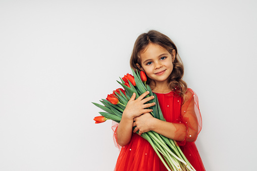 Cute blue-eyed girl holding a bouquet of tulips