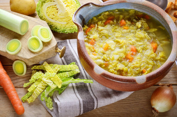 Savoy cabbage soup with potatoes leeks and carrots, close-up.