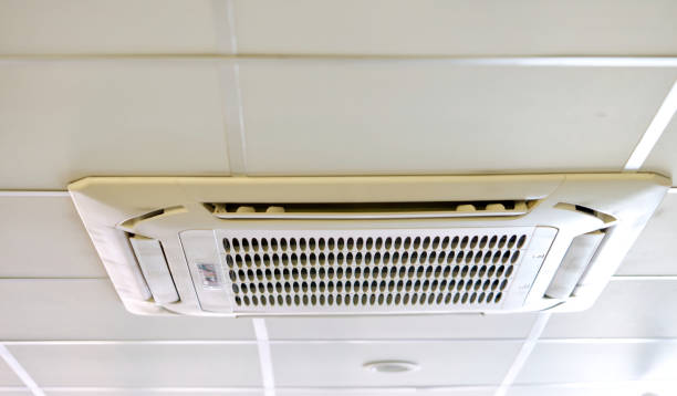 istock cassette type air conditioner mounted on ceiling wall. Air duct on ceiling in farmacy store. Air flow and ventilation system 1359736609